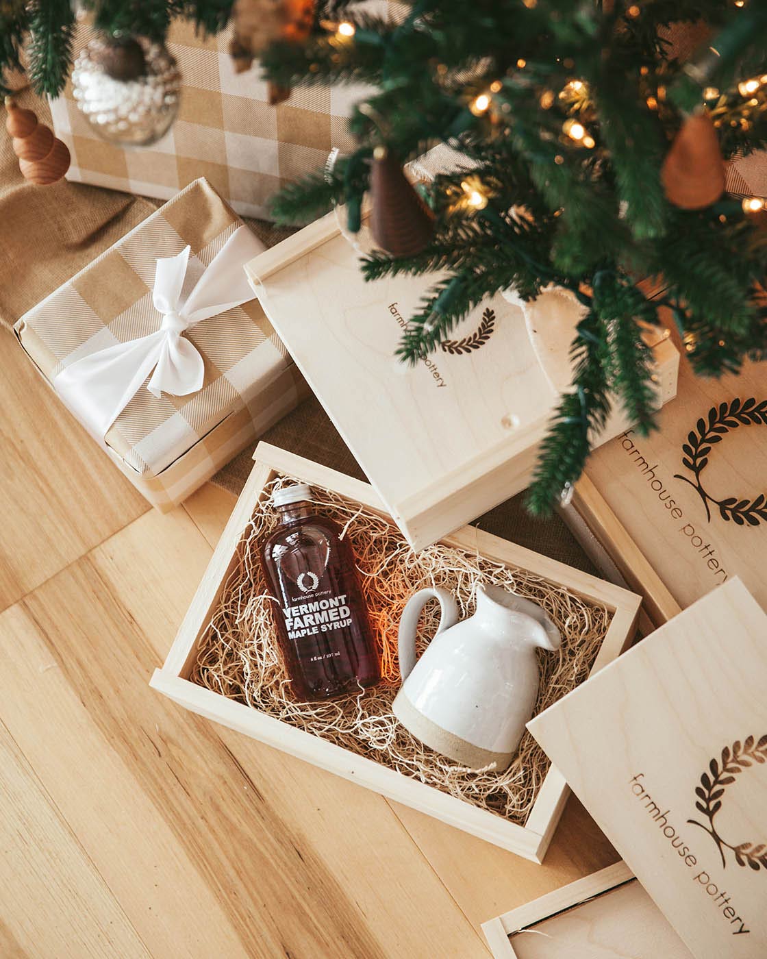 The Maple Syrup and Bell Pitcher Gift Set under a holiday tree