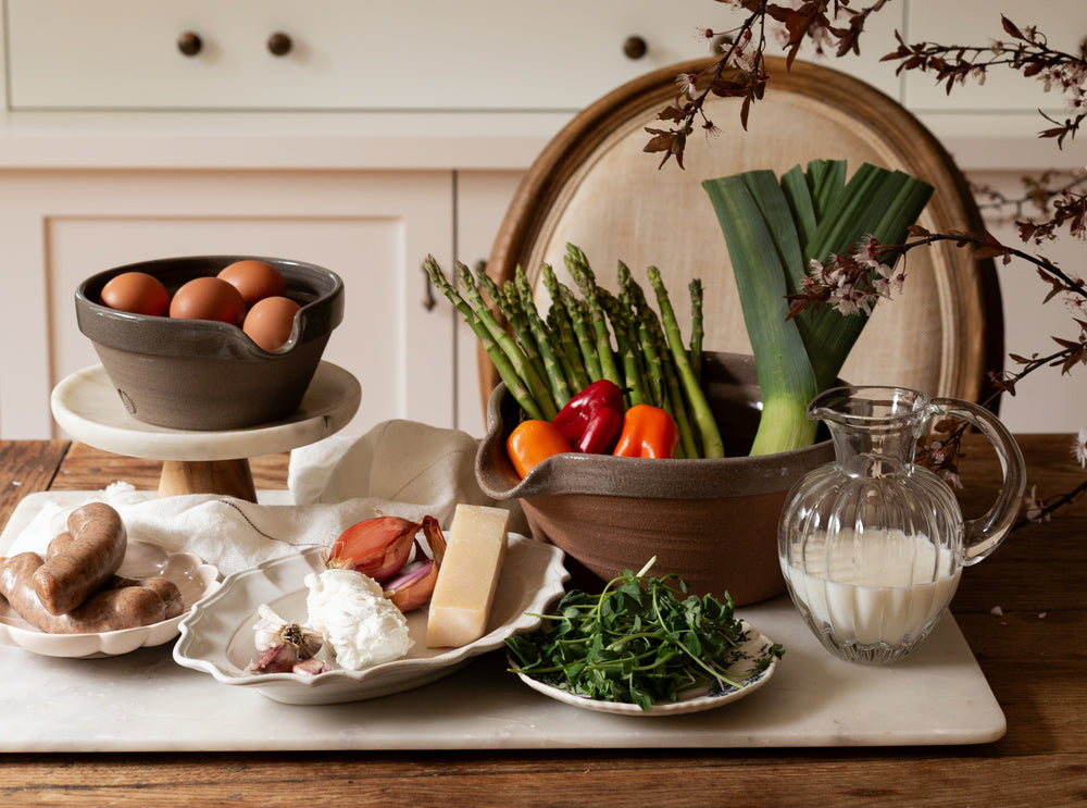Assorted fresh vegetables and kitchen items on a wooden table