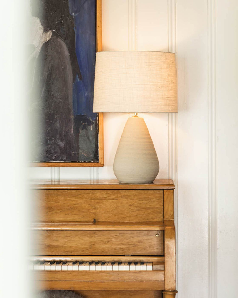The Large Teardrop Lamp in Oat on a piano