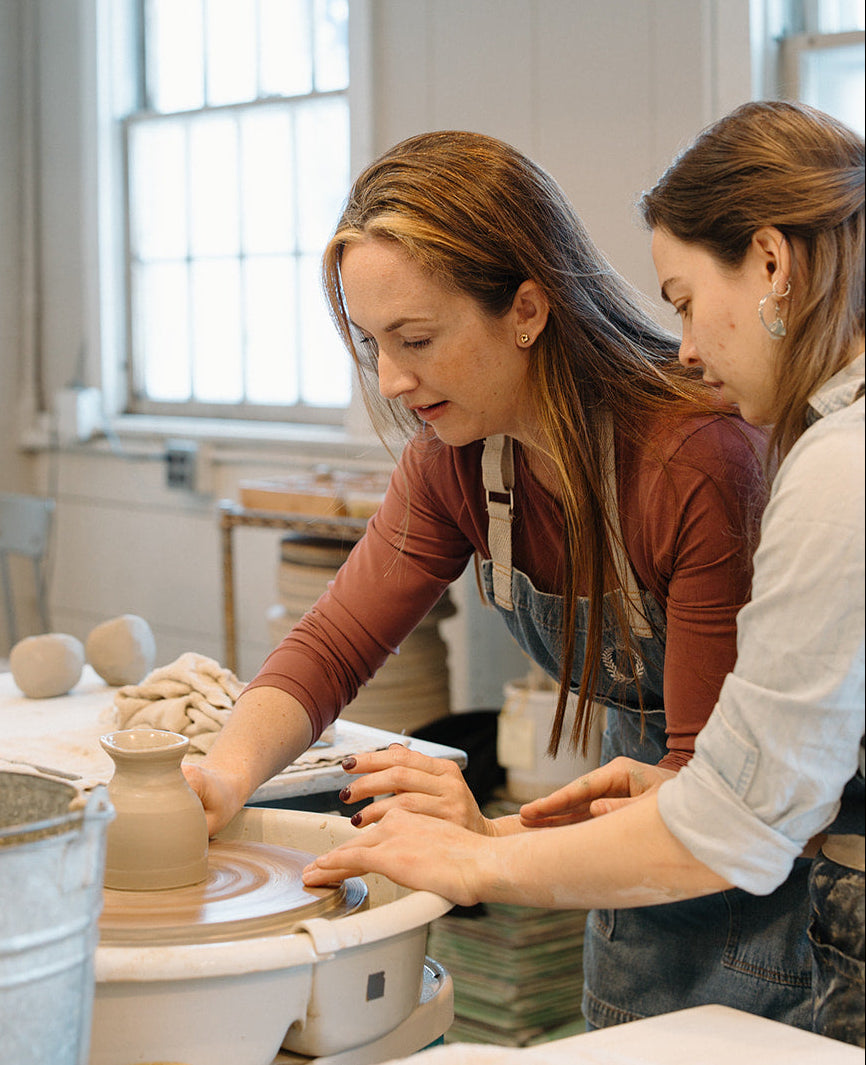 Two women working on pottery in a studio setting.